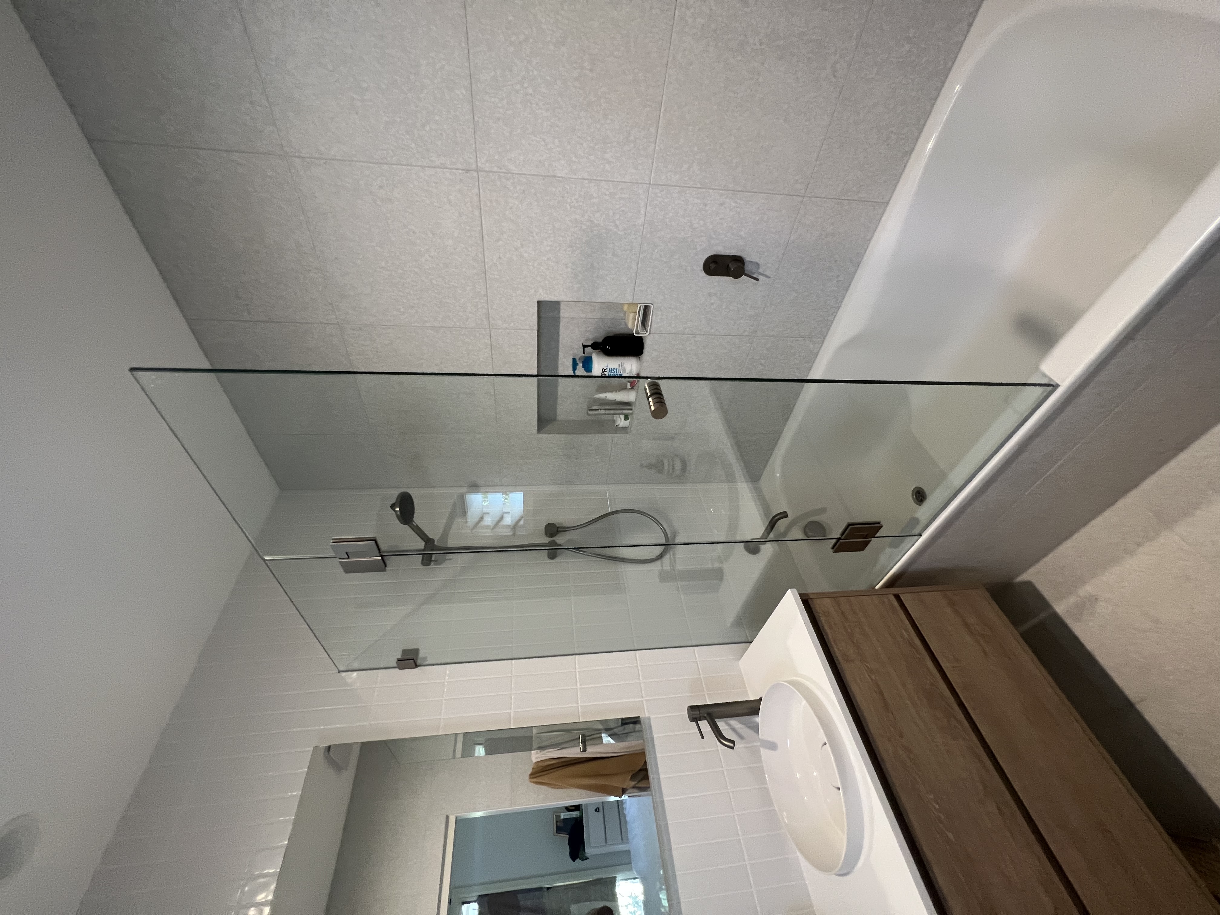Semi-frameless L-shape corner shower with chrome hardware