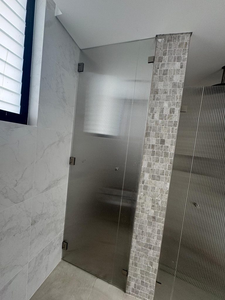 Frameless corner fluted glass shower with brushed nickel hardware