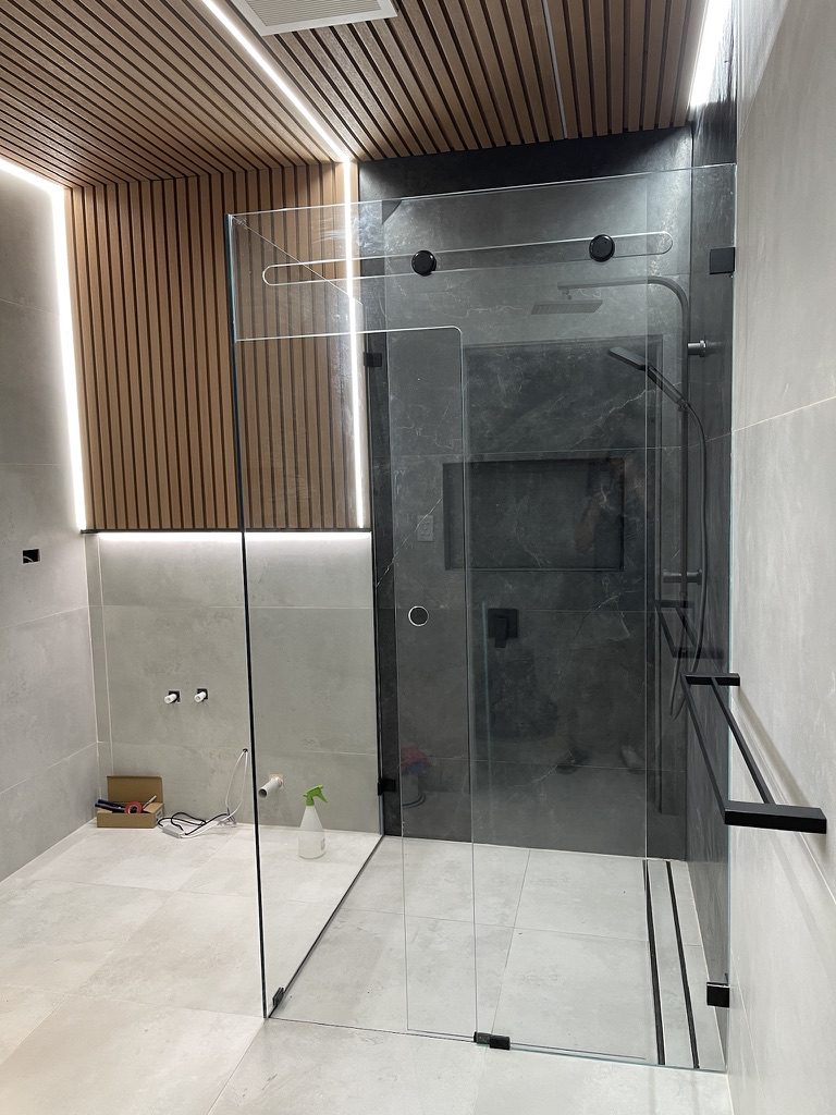 Frameless walk-in shower with smoked glass and timber slat ceiling