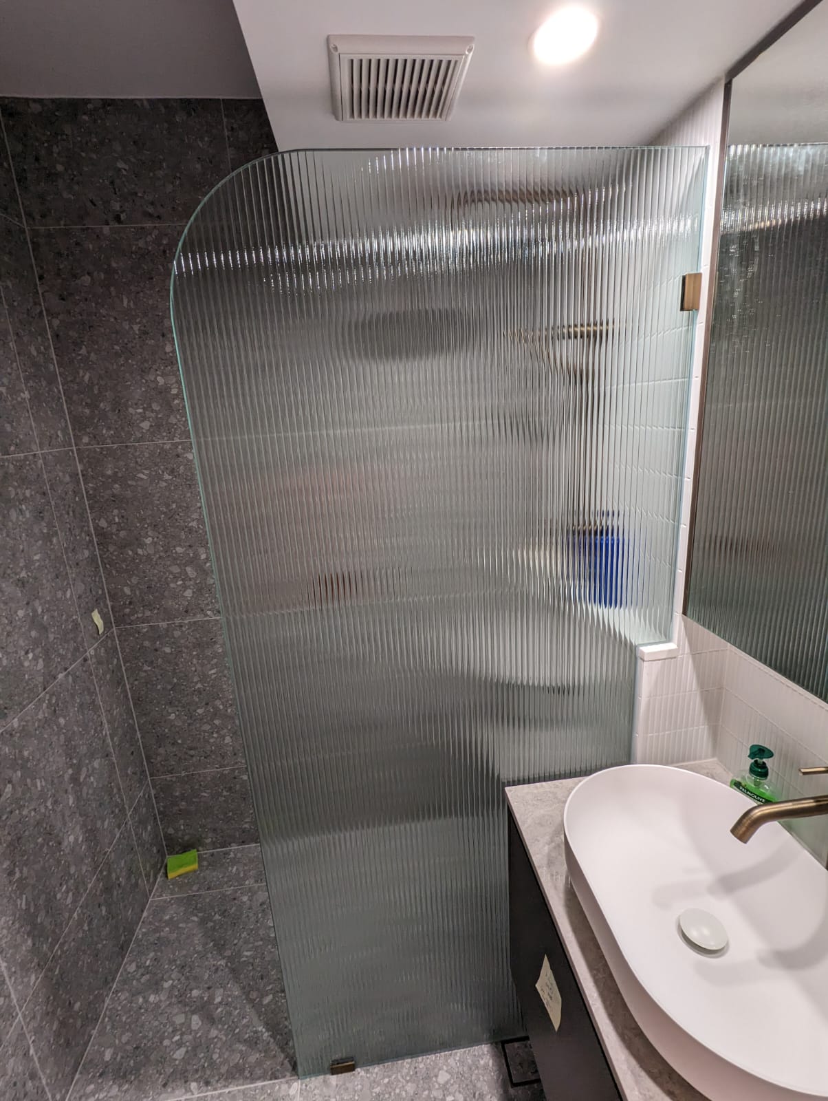 Frameless walk-in fluted shower with brushed gold hardware